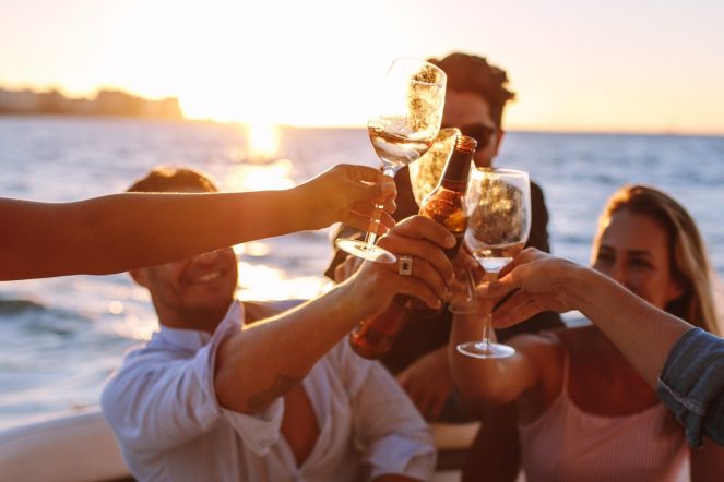 Sunset,Boat,Party,With,Young,People,Toasting,Drinks.,Group,Of
